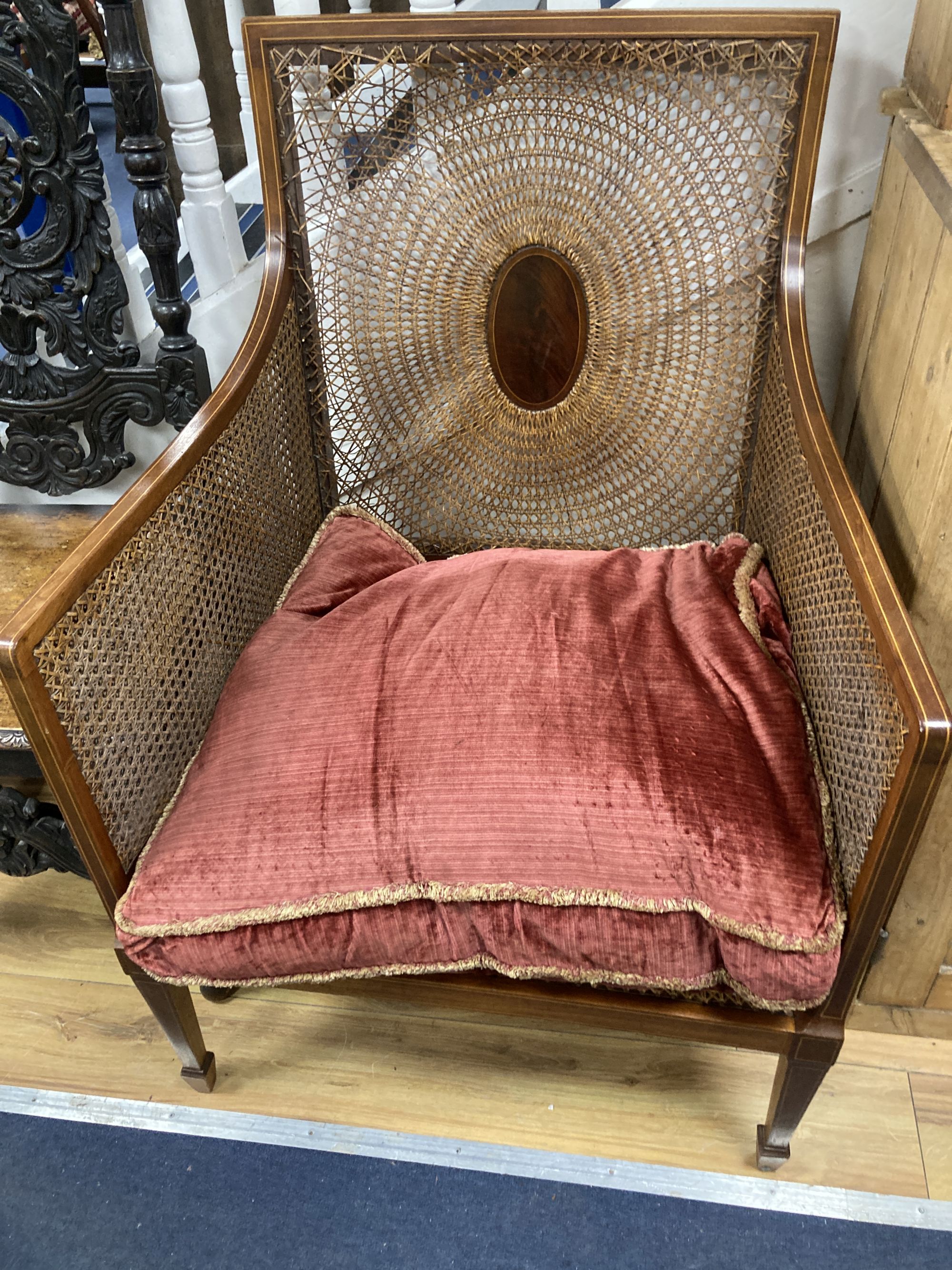 A Flemish carved oak dining chair and an Edwardian bergere chair